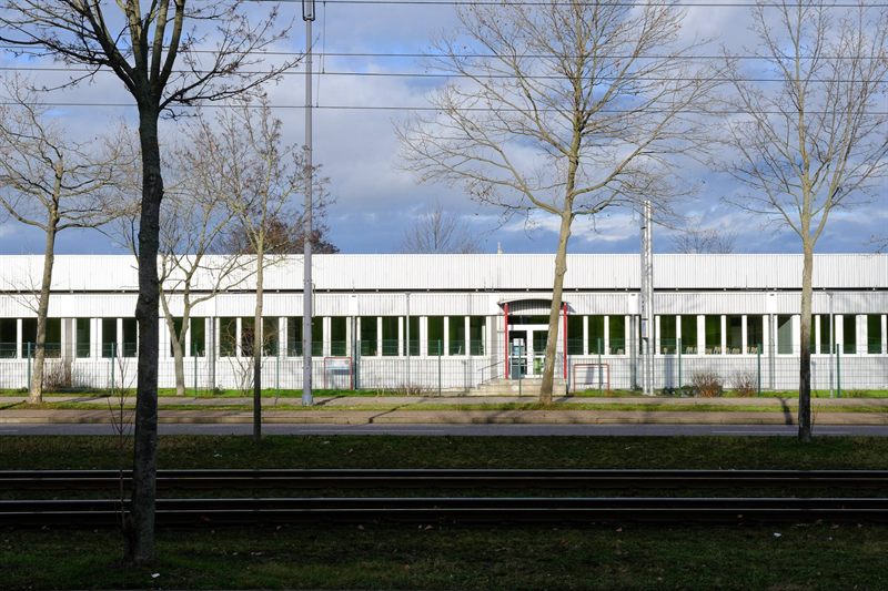 Campus building seen from the street, with the tram tracks in front